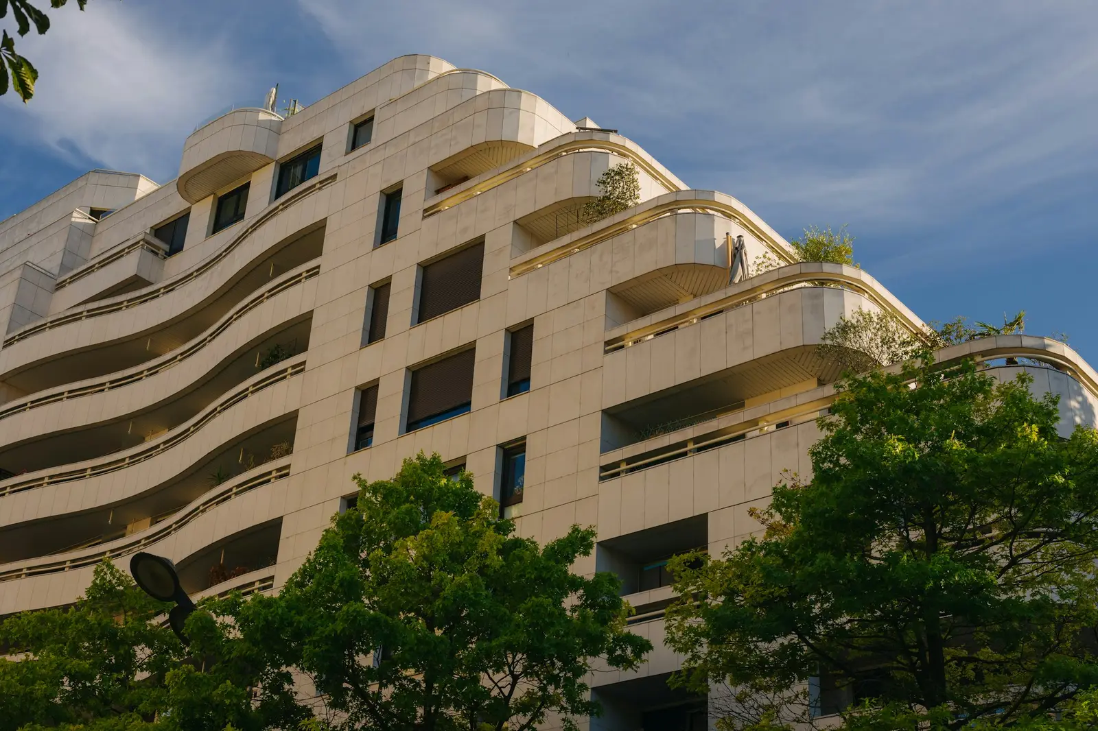 Dalgalı balkon hatlarına sahip krem renkli apartman cephesi